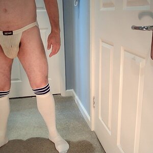 The ripe, rank and abused white swimmer jockstrap against the pure white of the football socks.