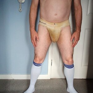A view showing the contrast between the rank and filthy jockstrap against pure white football socks.