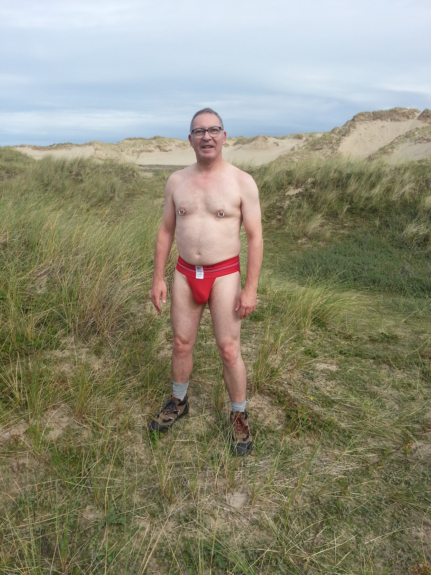 Front view of the red Wang Jiang jockstrap while walking through the dunes to get to the beach